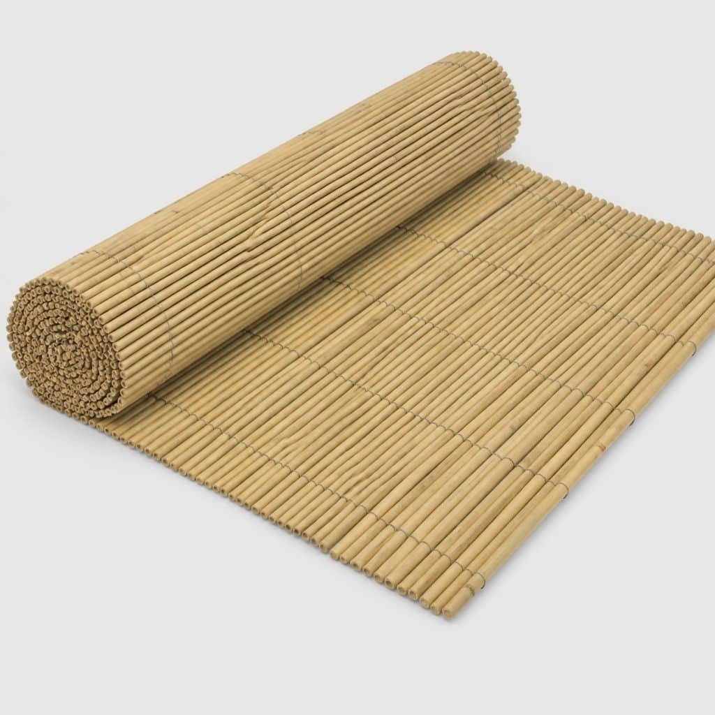 Grand rouleau de canisse bambou beige partiellement déroulé sur fond neutre